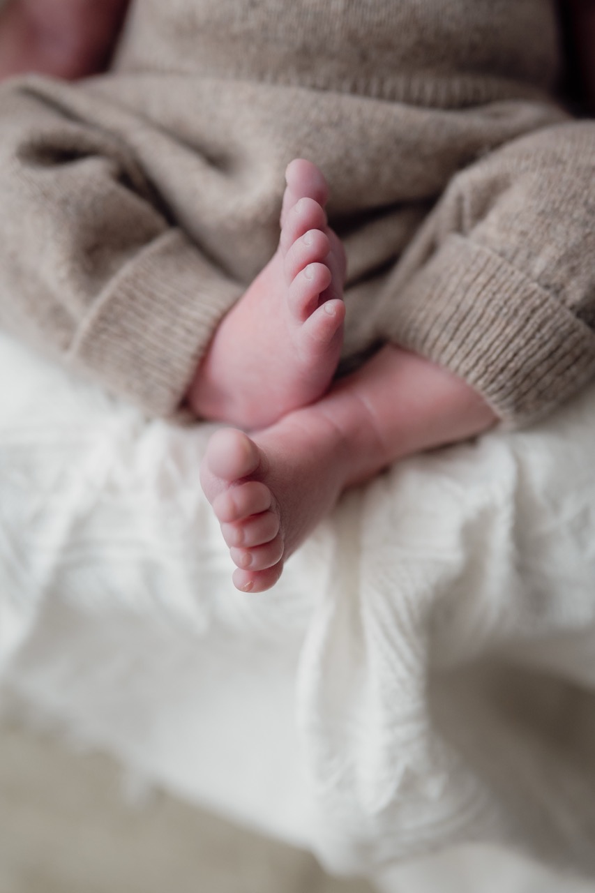 Babyfoto wo die Füße in einem Korb liegen