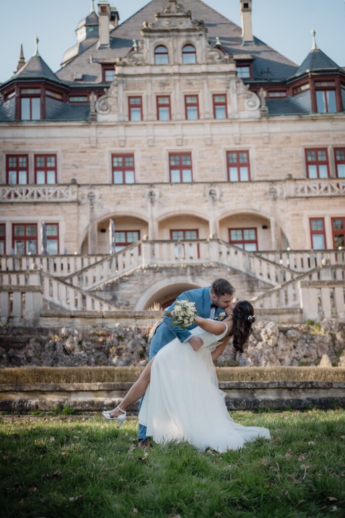 Hochzeitsfotos eines Brautpaares welches den Deep Kiss vor dem Schloß Wolfsbrunnen durchführt