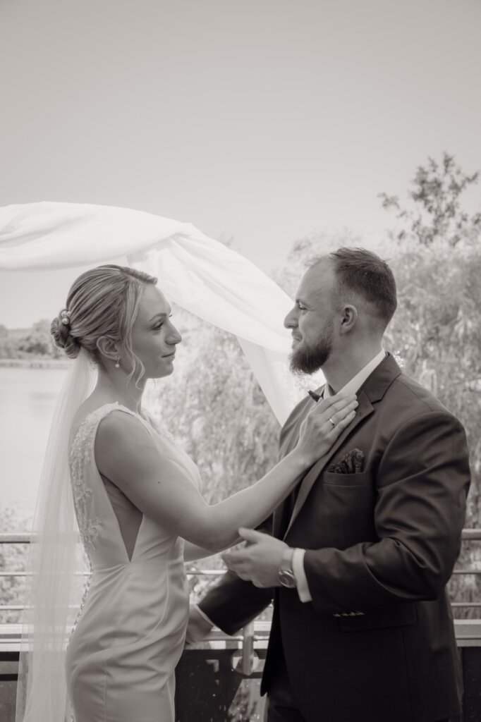 Brautpaar umarmt sich , sie fasst ihn ganz lieb am Hals an und sie lächeln sich an