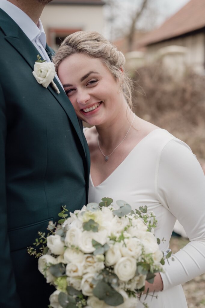 Hochzeitsfoto der Braut die Ihren Kopf auf die Brust des Mannes legt in einem Schloss