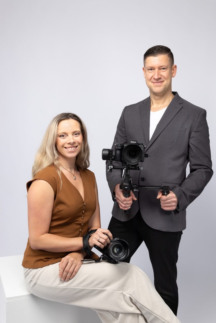 Videografenpaar steht mit den Kameras vor der Kamera